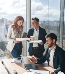 smiling-businessmen-drink-coffee-and-discussing-documents-with-graphs-and-charts-1.jpg